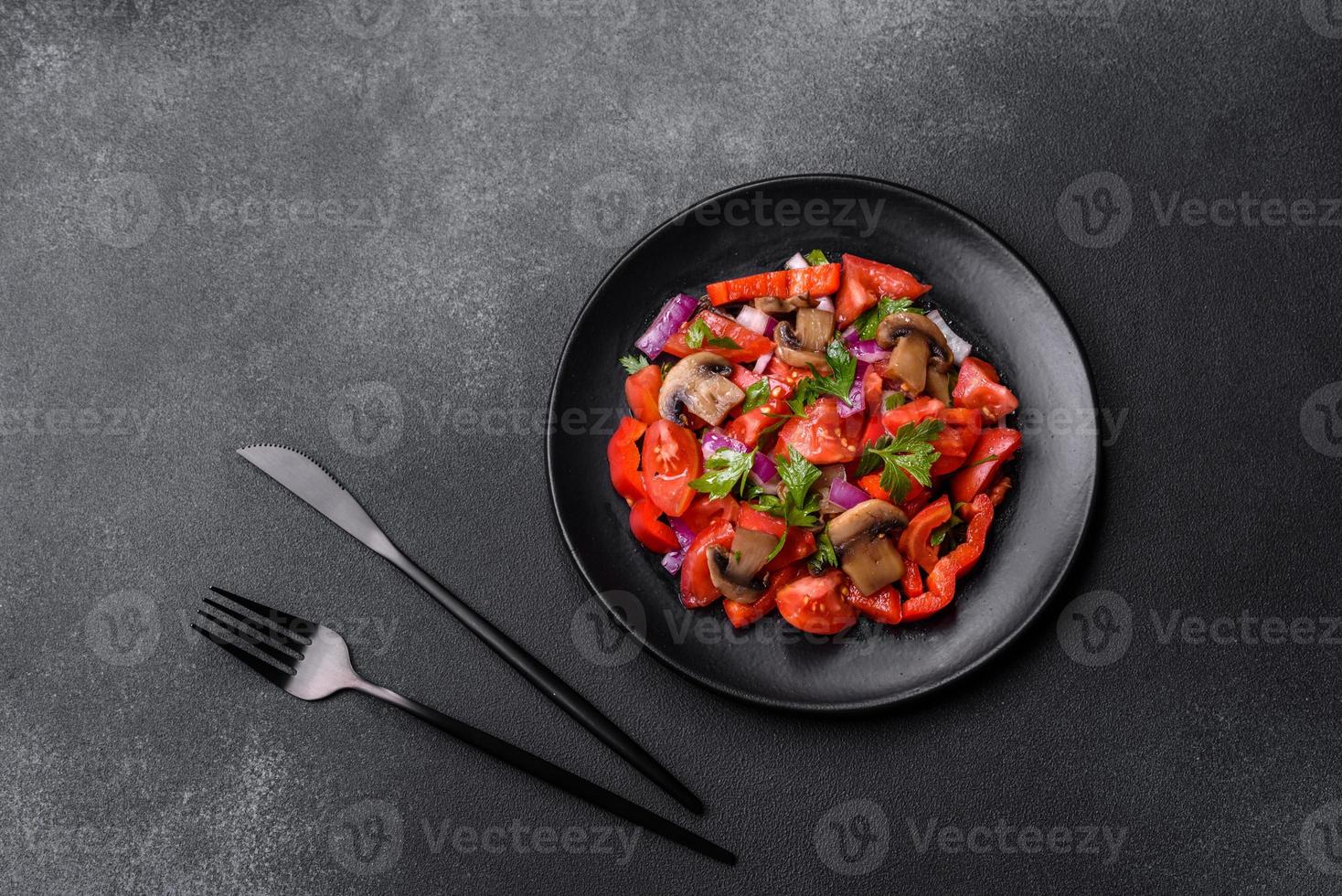 A salad of baked mushrooms, tomatoes, onions, parsley, spices and herbs photo