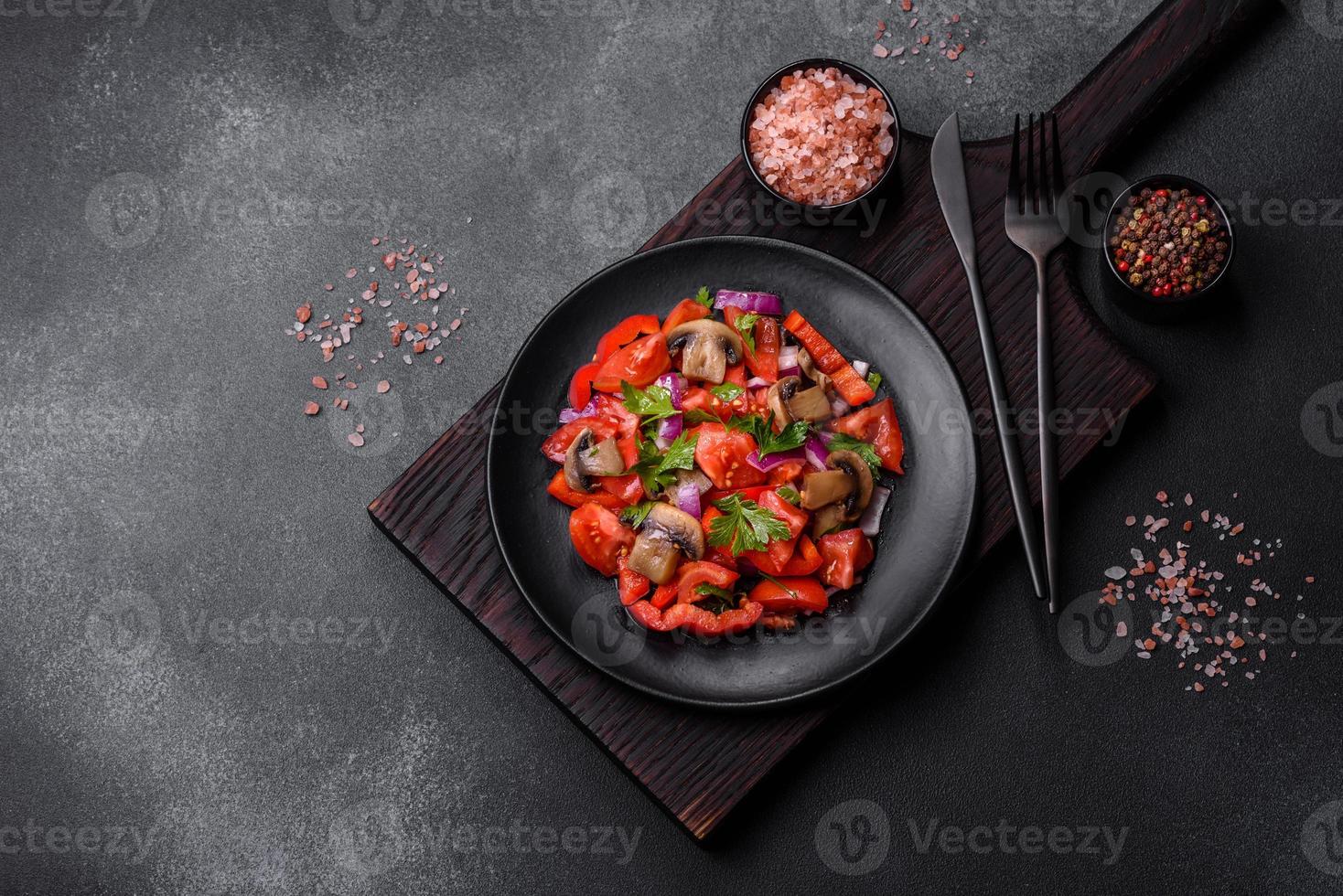 A salad of baked mushrooms, tomatoes, onions, parsley, spices and herbs photo