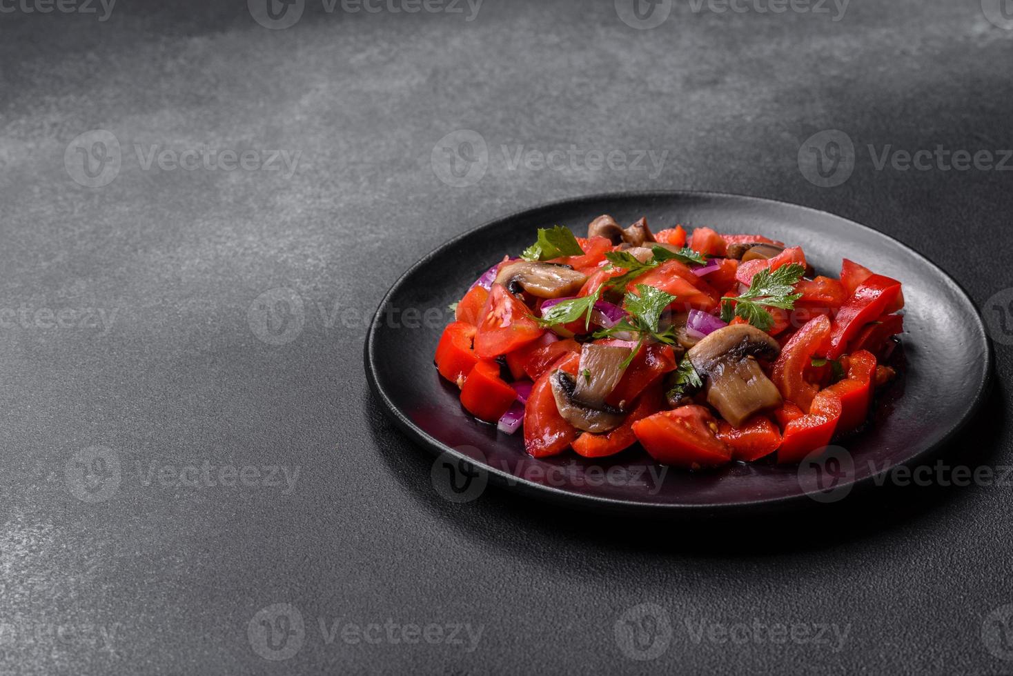 A salad of baked mushrooms, tomatoes, onions, parsley, spices and herbs photo