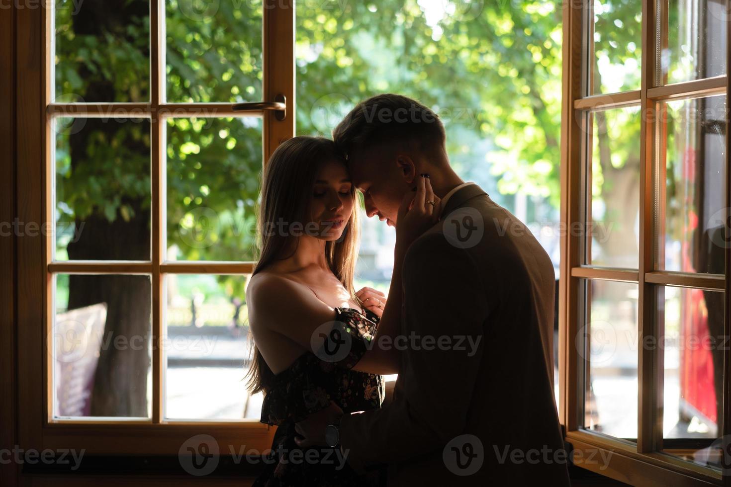 Young couple in love standing by the window photo