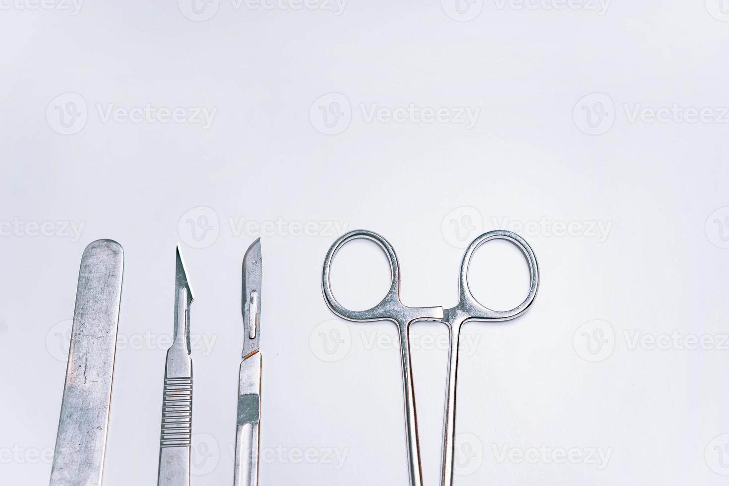 Scapula for throat, two scalpels and clamp on a light background photo