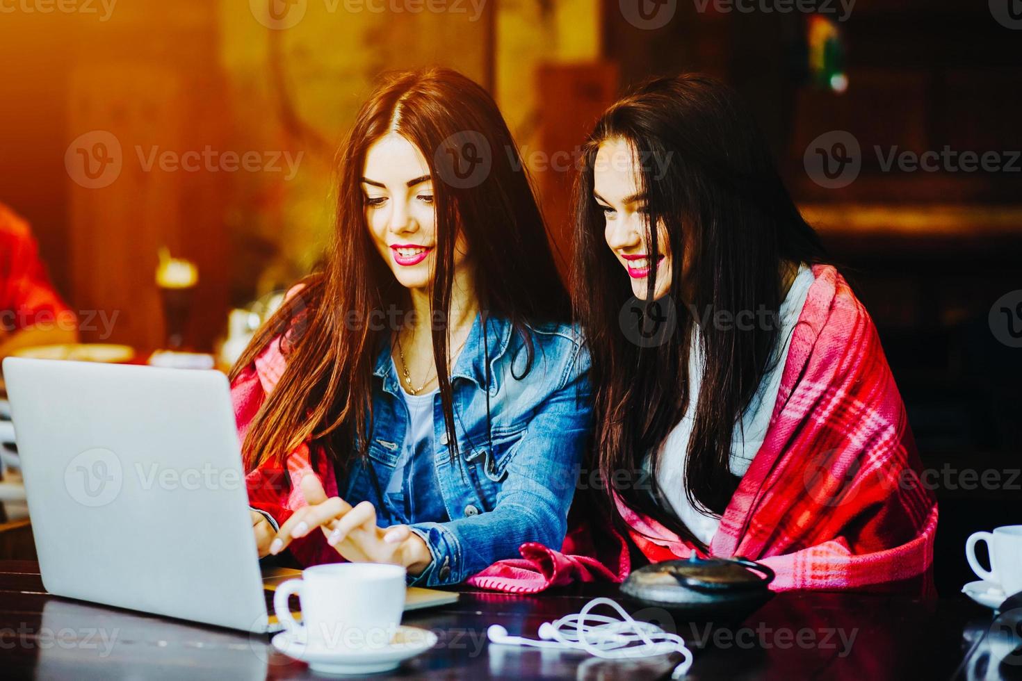 two girls watching something in laptop photo