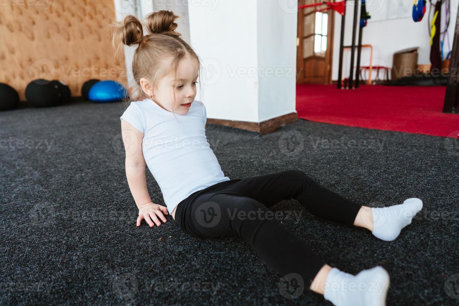 Little girl is doing exercises photo