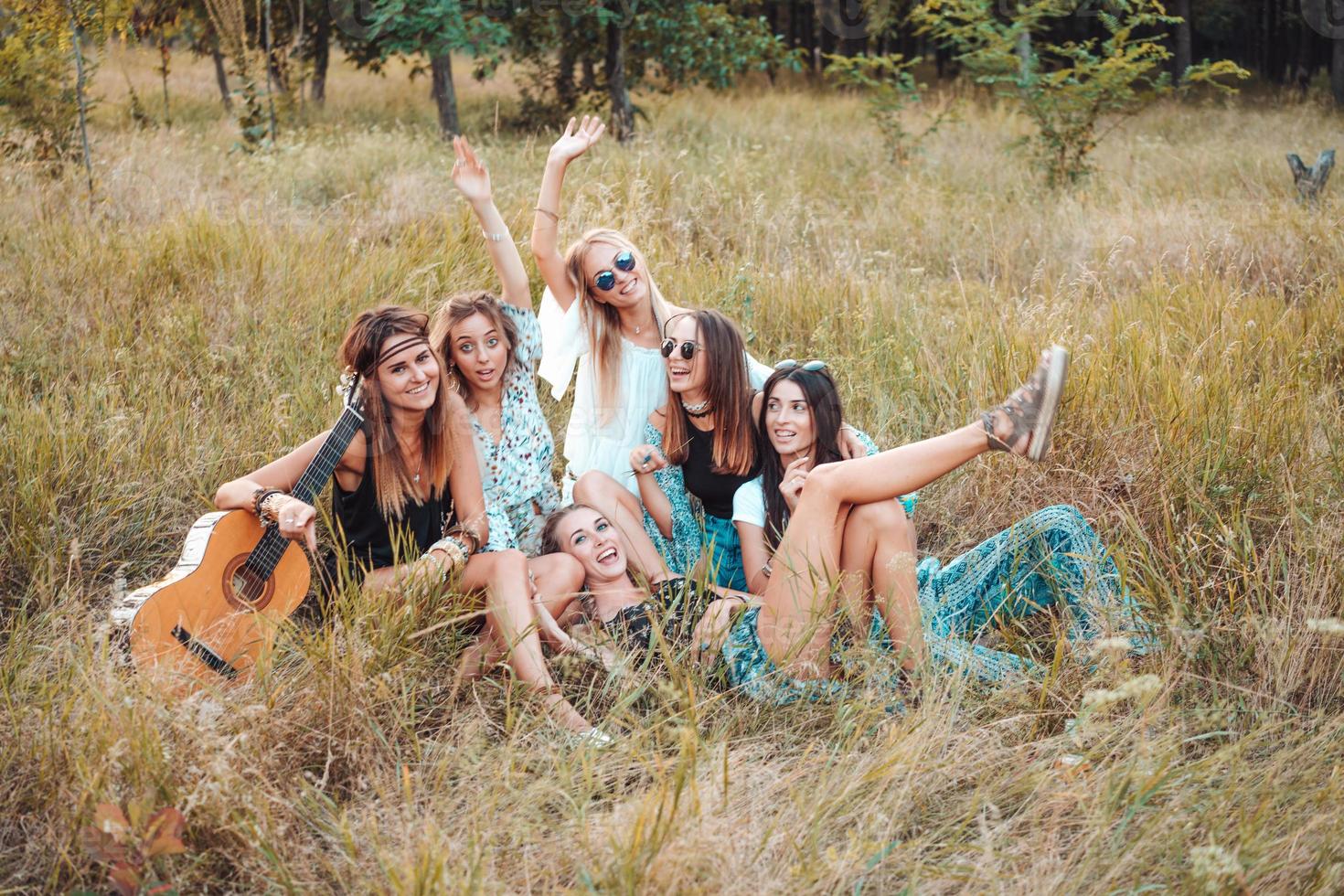 Six girls in nature are sitting on the grass. photo