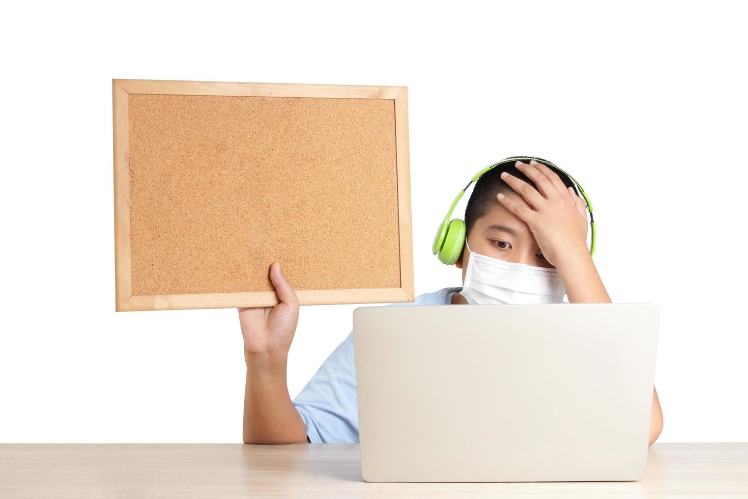 Asian boys learn online from home through video calls, using their laptop computers to communicate with their teachers. Hold a wooden sign for writing messages. Education concept Social distance. photo