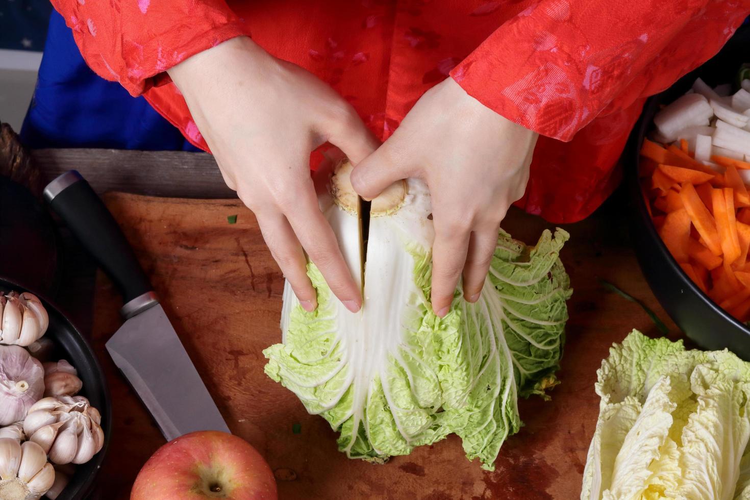 Korean women wear traditional red hanboks, make kimchi by tearing the Chinese cabbage. The concept of cooking fermented foods that are charming and fragrant, Asian cuisine from folk wisdom photo