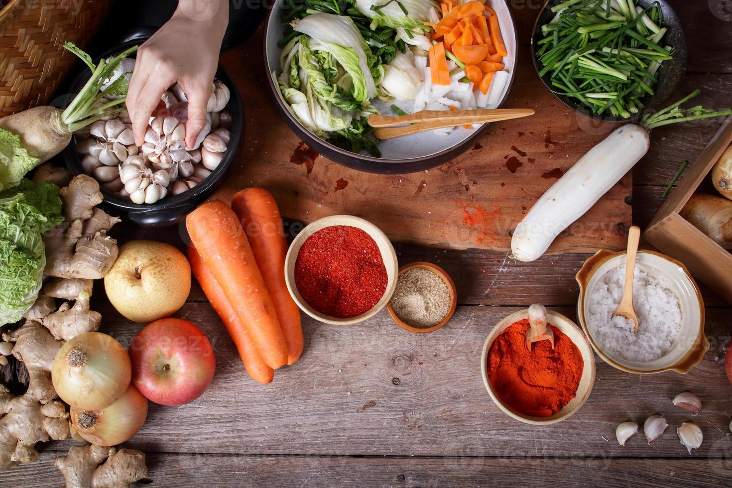 Korean kimchi pickles ingredients There are radishes, carrots, Chinese cabbage, apples, onions, garlic, salt, peppers, Gochujang. Fermented food concept. Top view photo