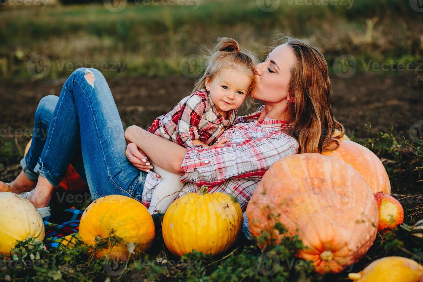 madre e hija yacen entre calabazas foto