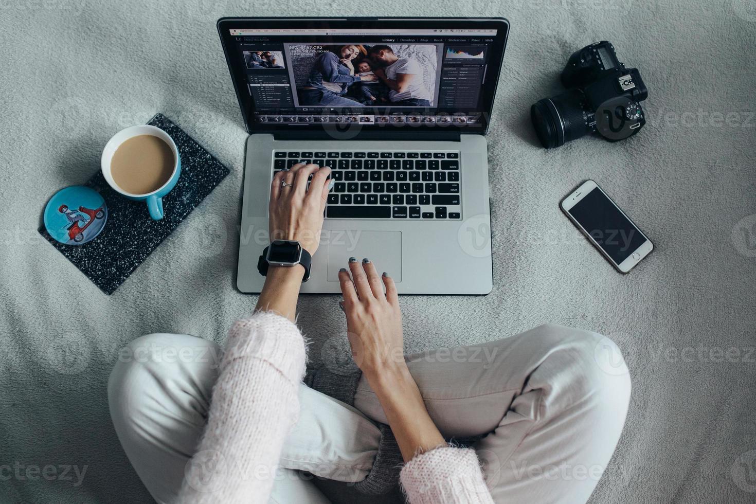 Woman using laptop on her bed photo