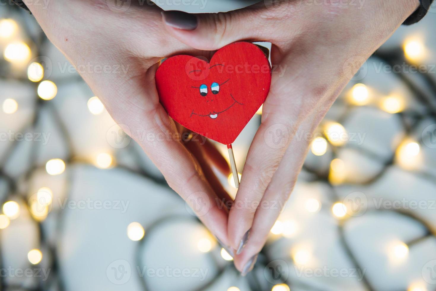 girl holding a red heart in the hands photo