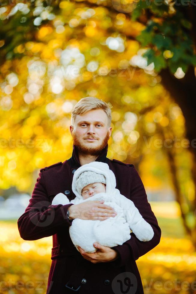 dad and newborn son in autumn park photo