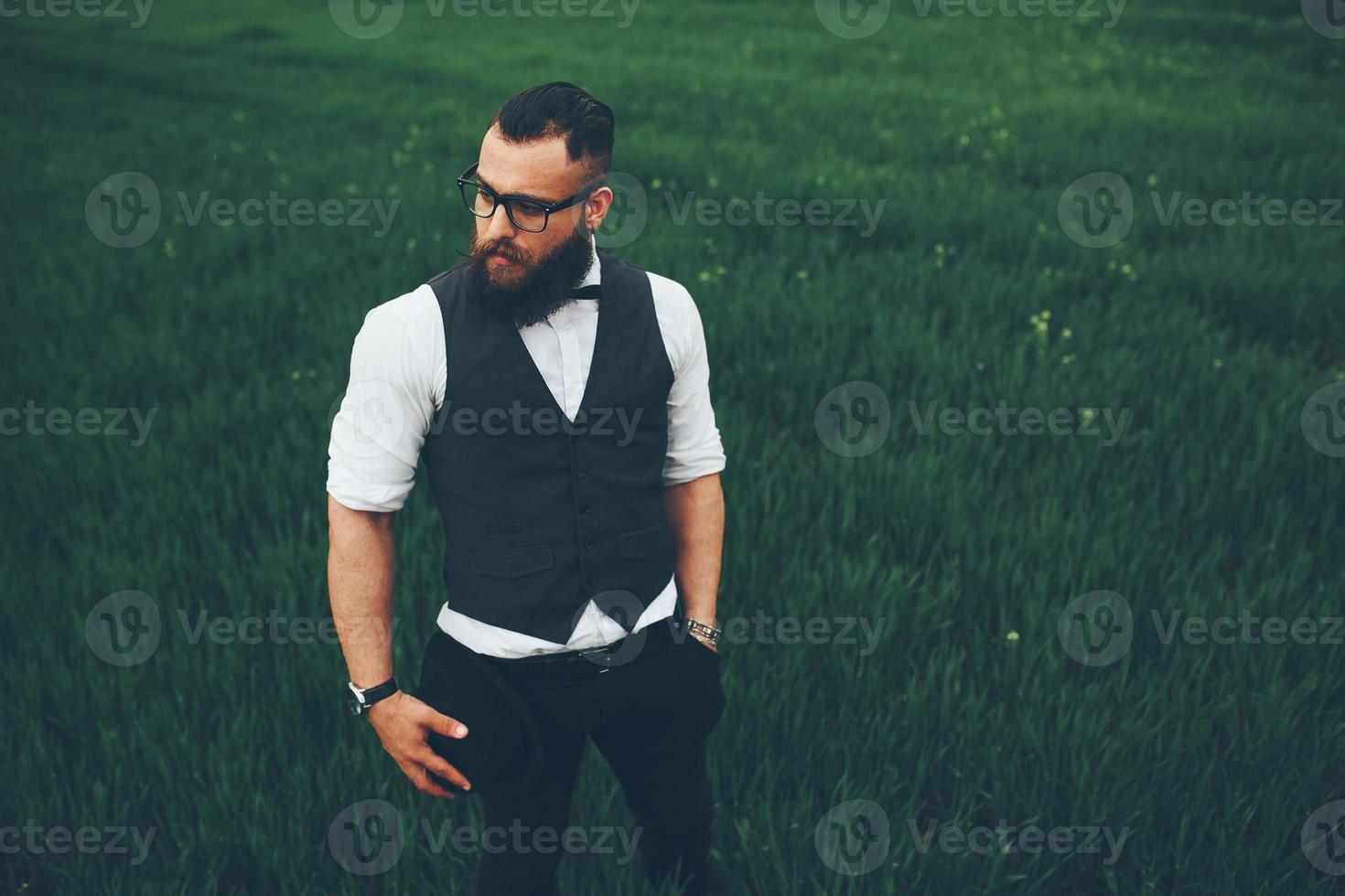 A man with a beard and sunglasses walking on the field photo
