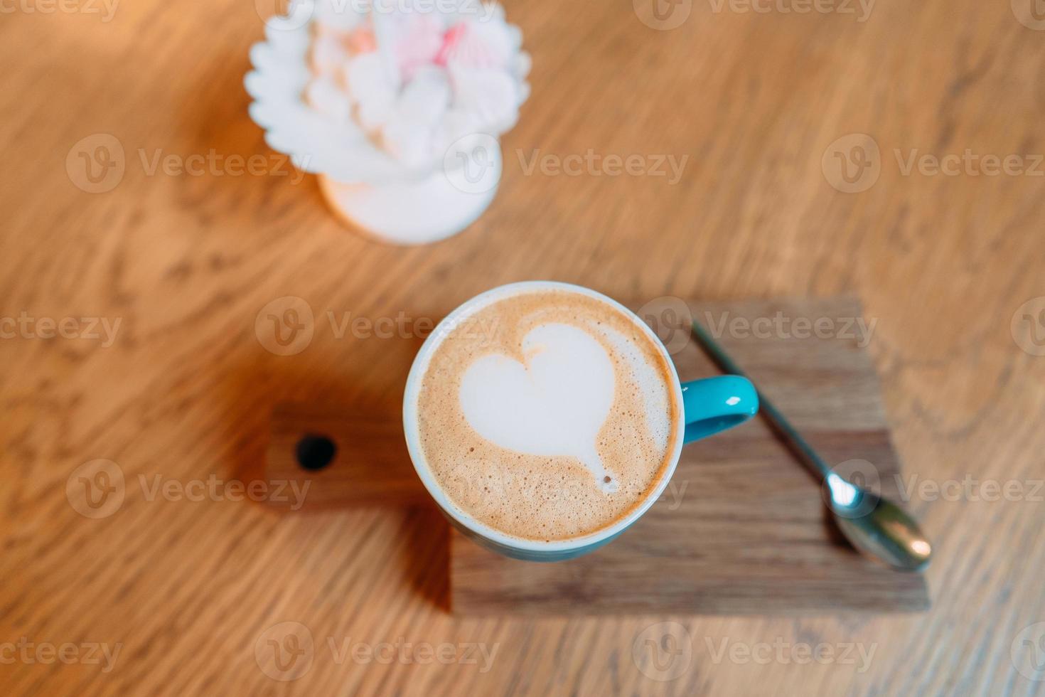 Latte hot coffee in a green cup with latte art photo