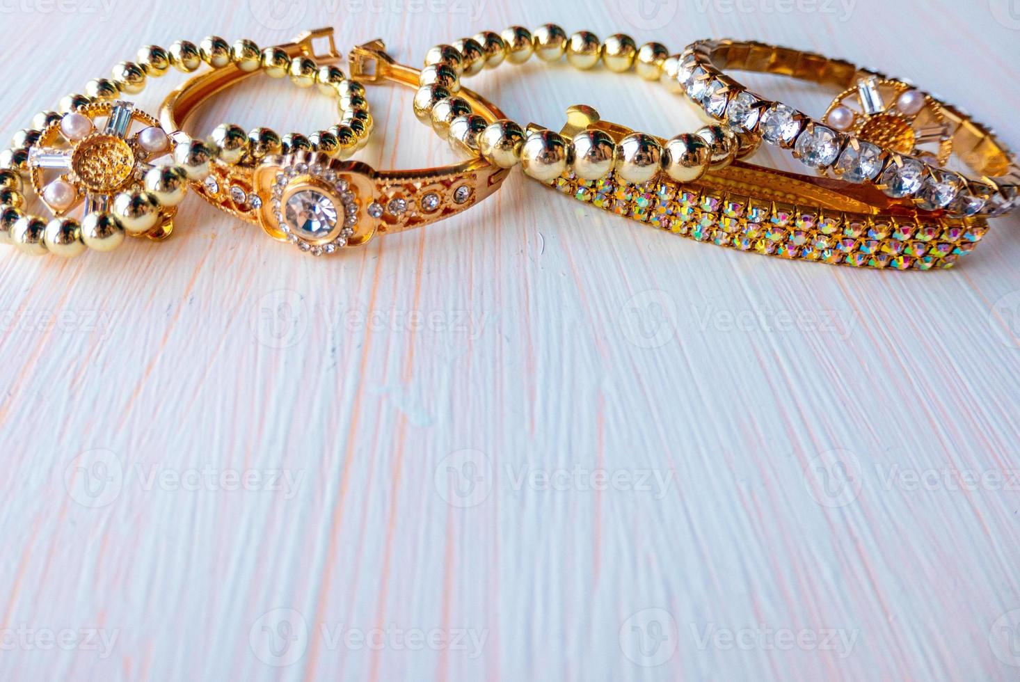 a lot of gold costume jewelry with different materials on a white background. Copy space photo