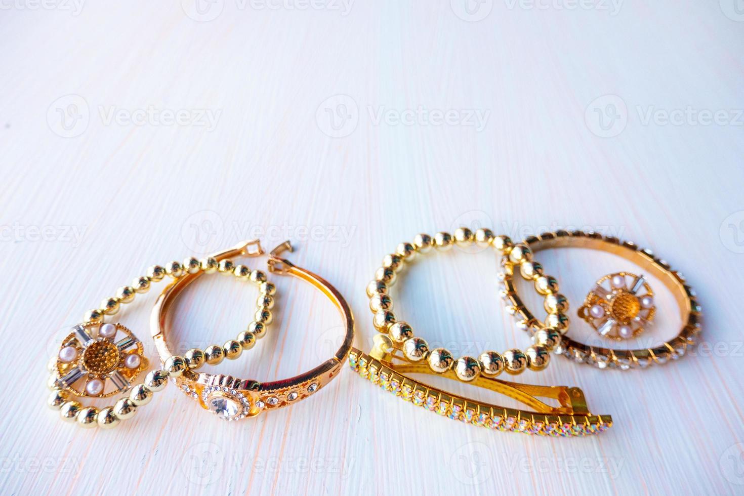 a lot of gold costume jewelry with different materials on a white background. Copy space photo