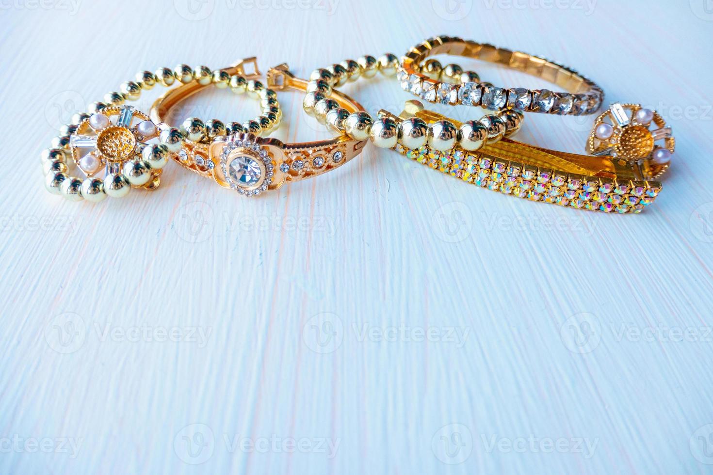 a lot of gold costume jewelry with different materials on a white background. Copy space photo