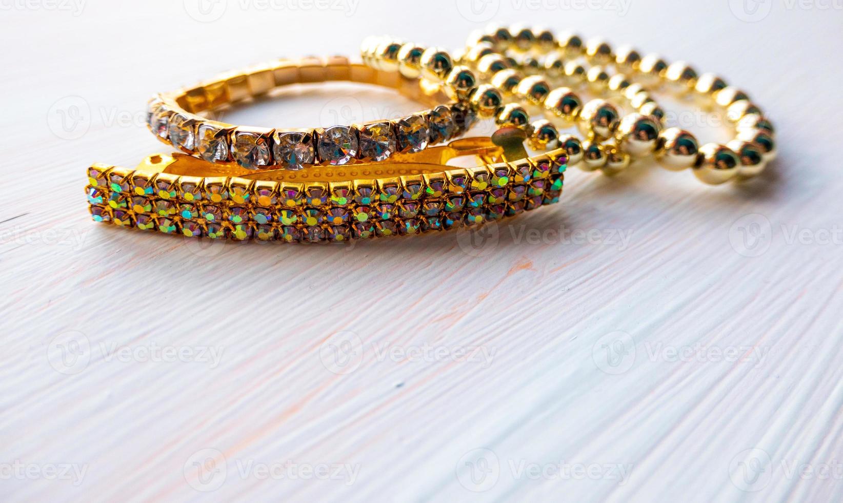 a lot of gold costume jewelry with different materials on a white