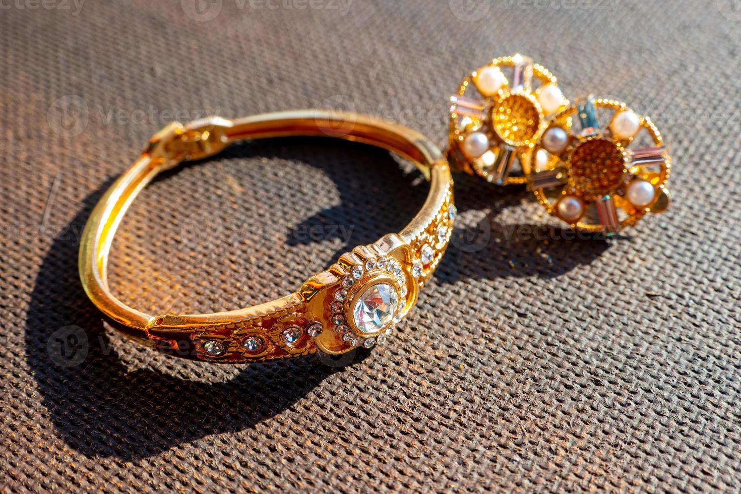 Set of a luxury elegant bracelet and earrings on a dark background photo