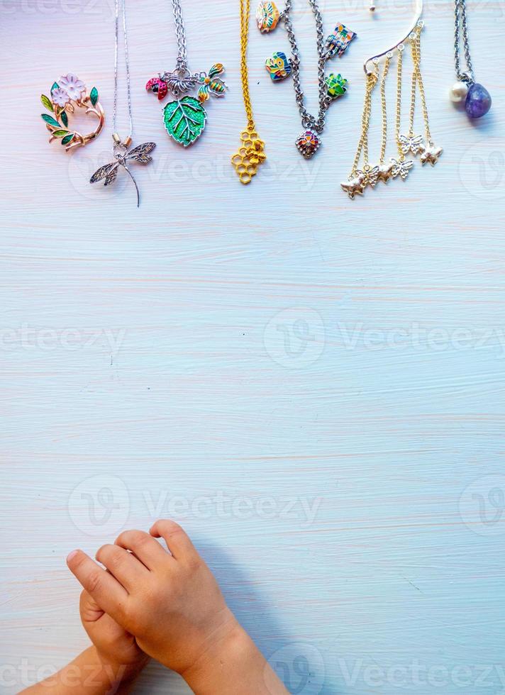 childrens hands play with light summer bijouterie, on white background. concept of womens happines. Copy space photo