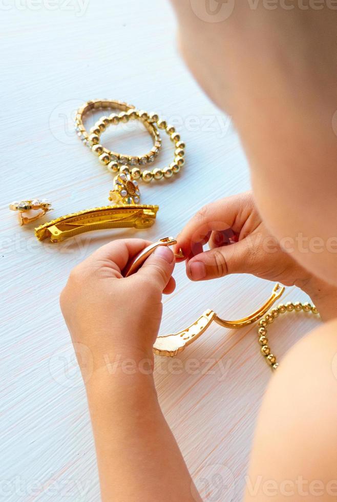 childrens hands play with gold jewelry and bijouterie, on white background. concept of womens happines photo