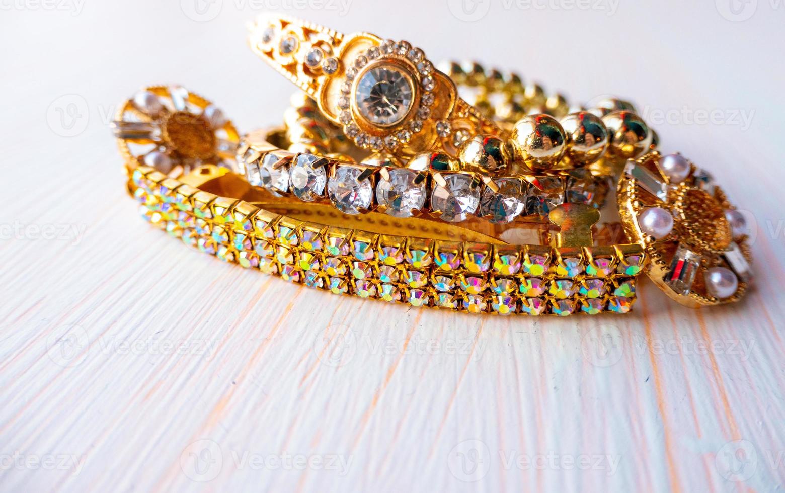 a lot of gold costume jewelry with different materials on a white background photo