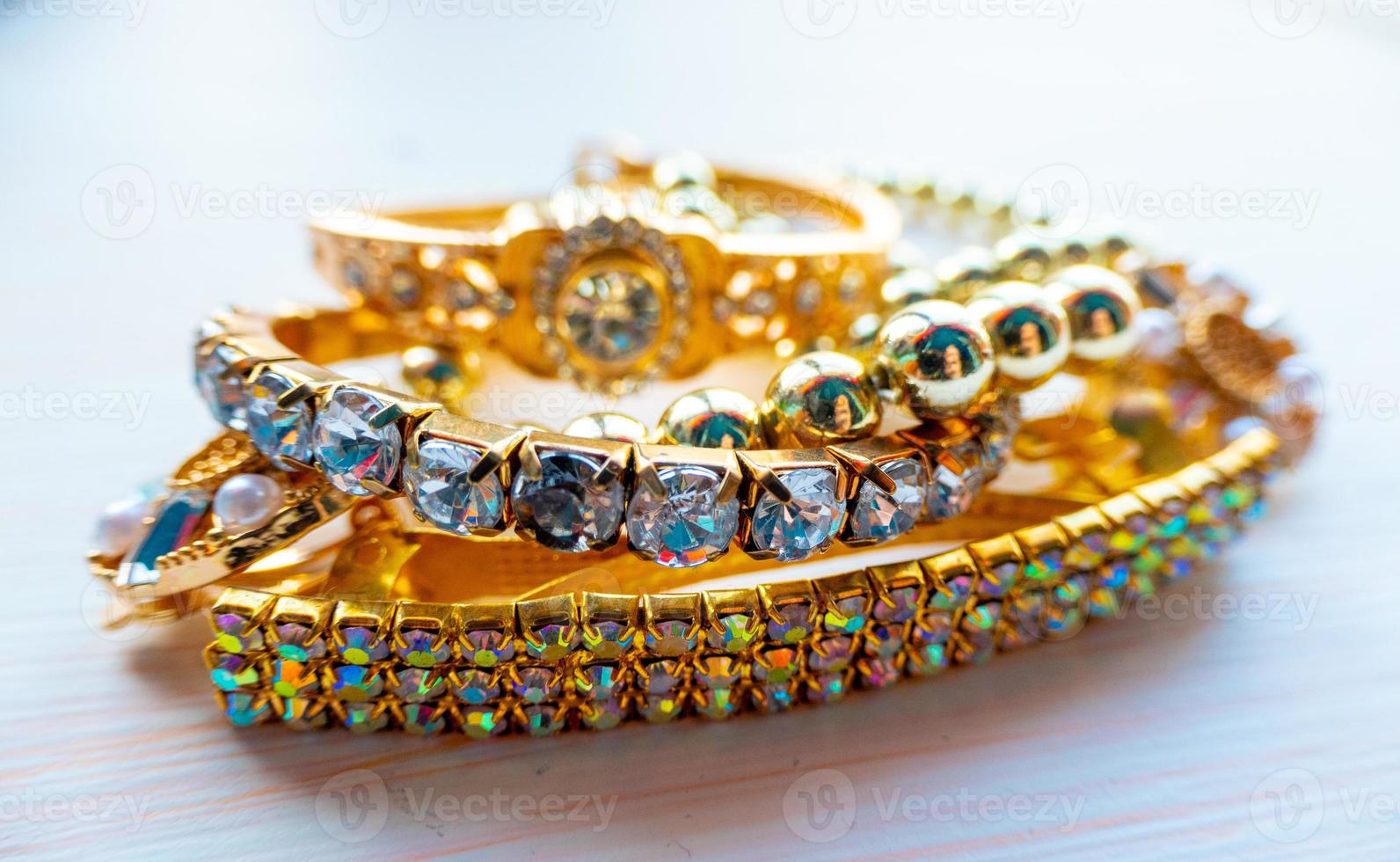a lot of gold costume jewelry with different materials on a white background photo