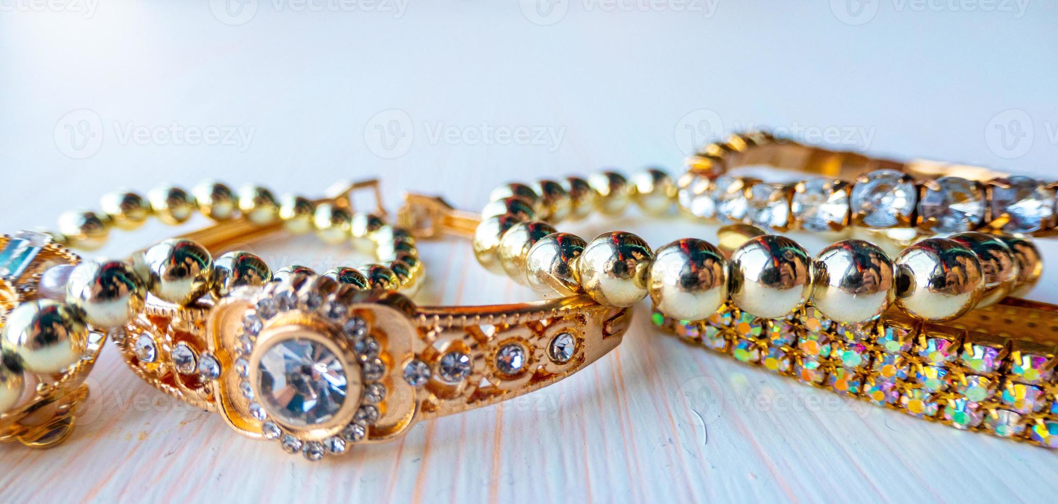 a lot of gold costume jewelry with different materials on a white