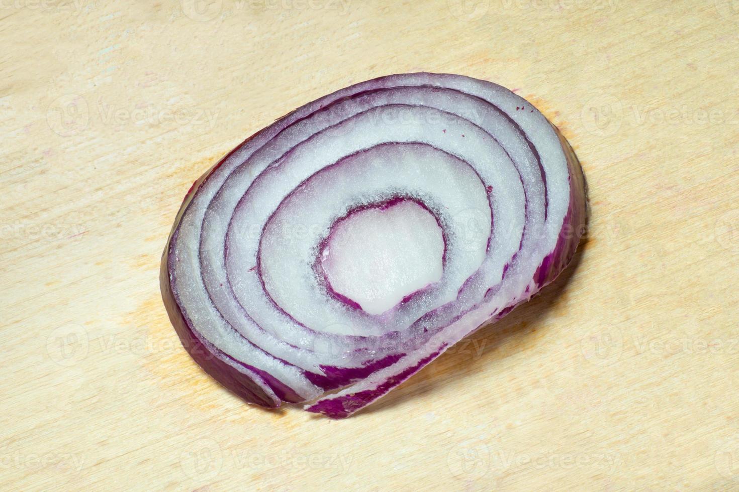 A slice of lilac onion on a kitchen board. photo