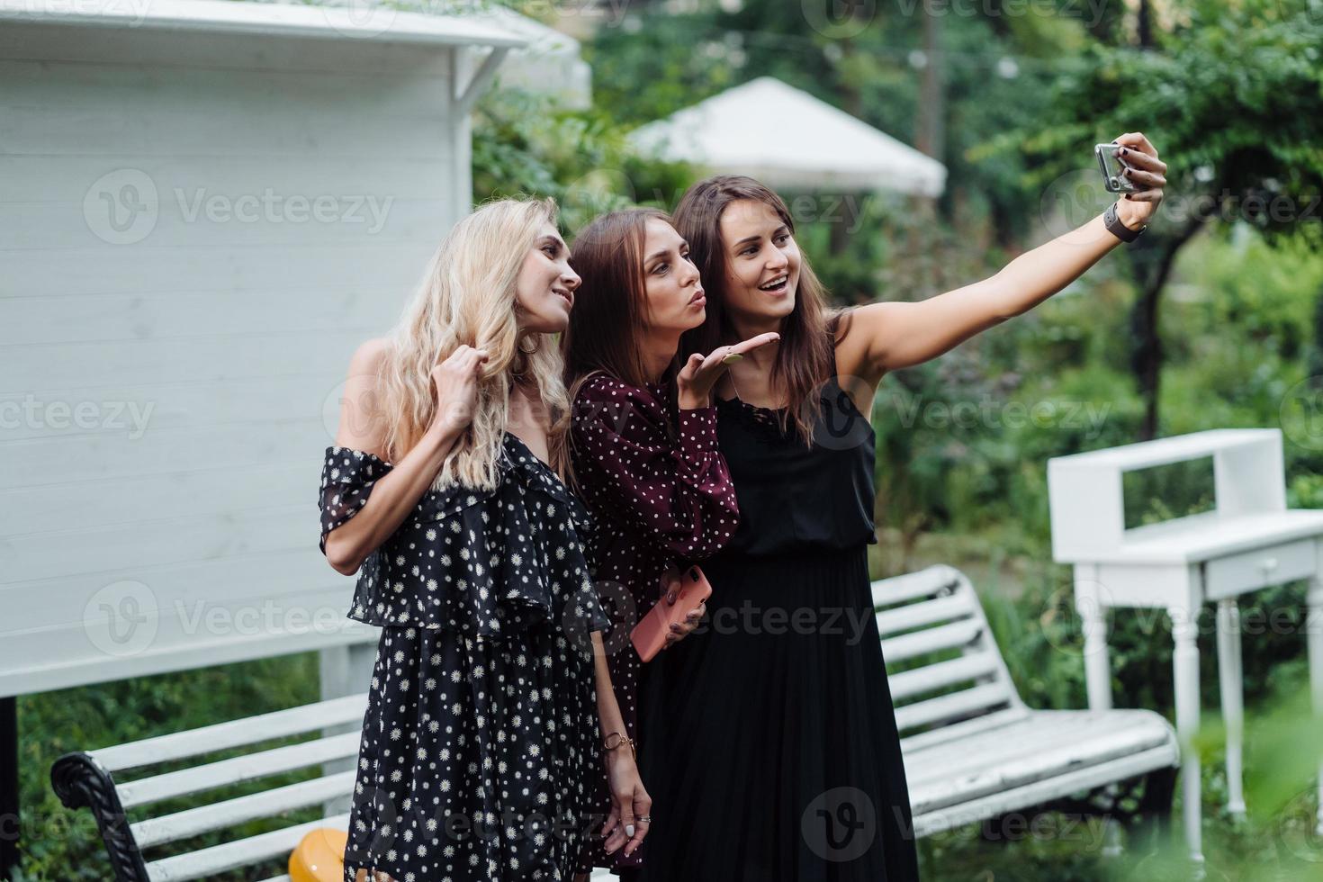 Three girls make selfies photo