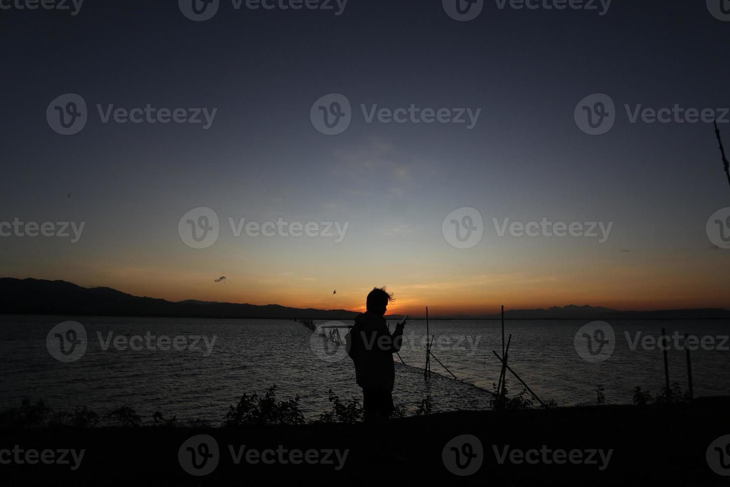 silhouette of a people on the lake photo