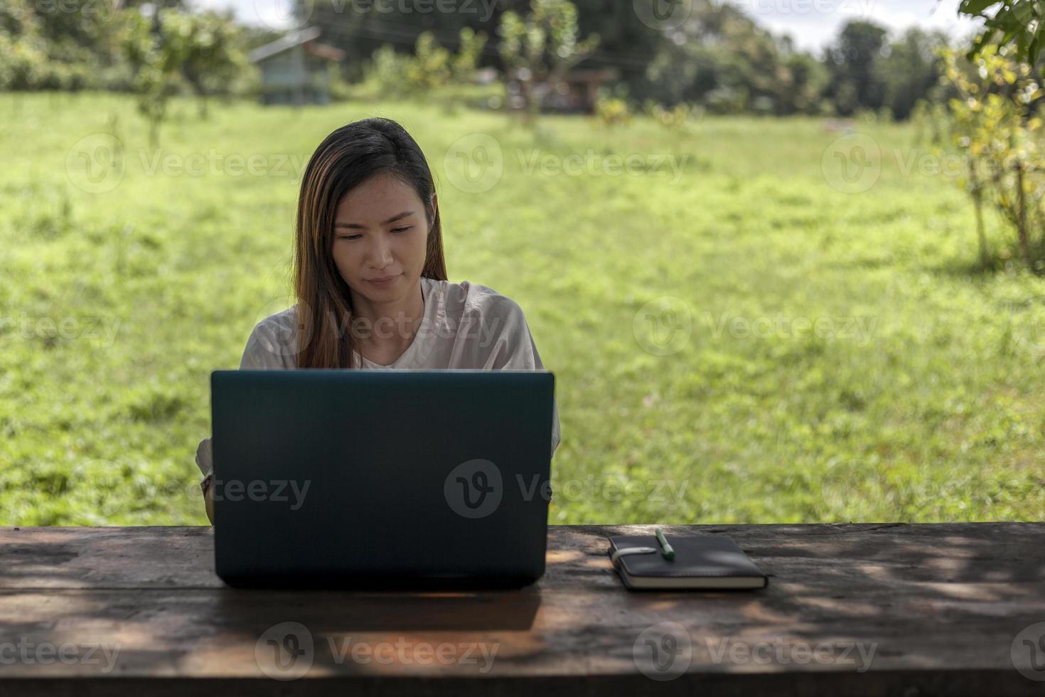 Asian women working with laptops in a shady farm environment Work at home concept photo