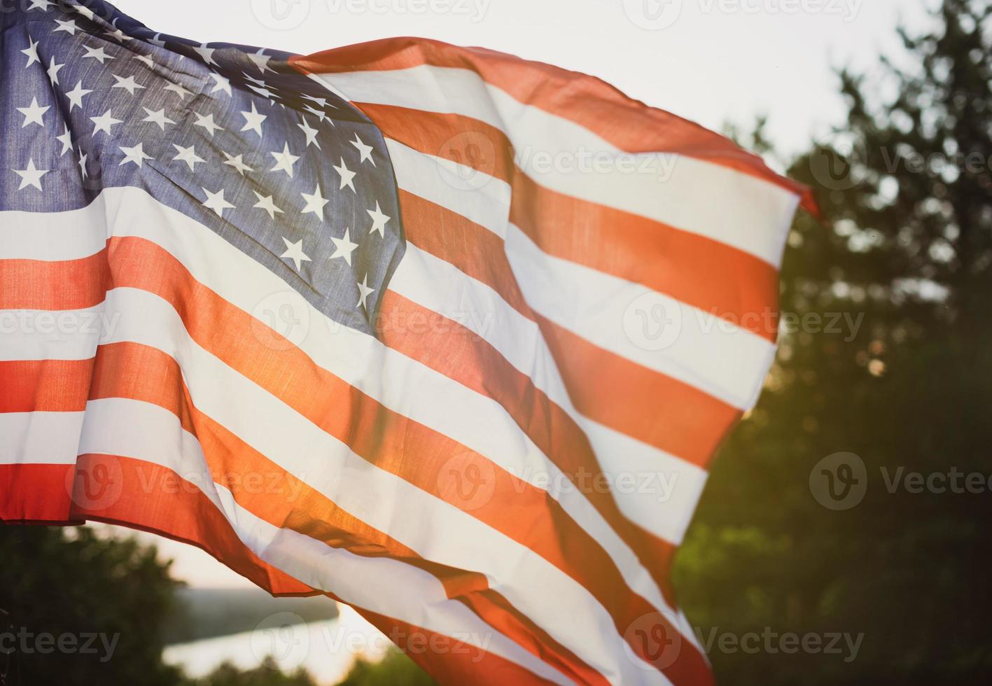 Veterans Day Flag Of The United States Of America. American flag flying on the background of the setting sun in nature. photo