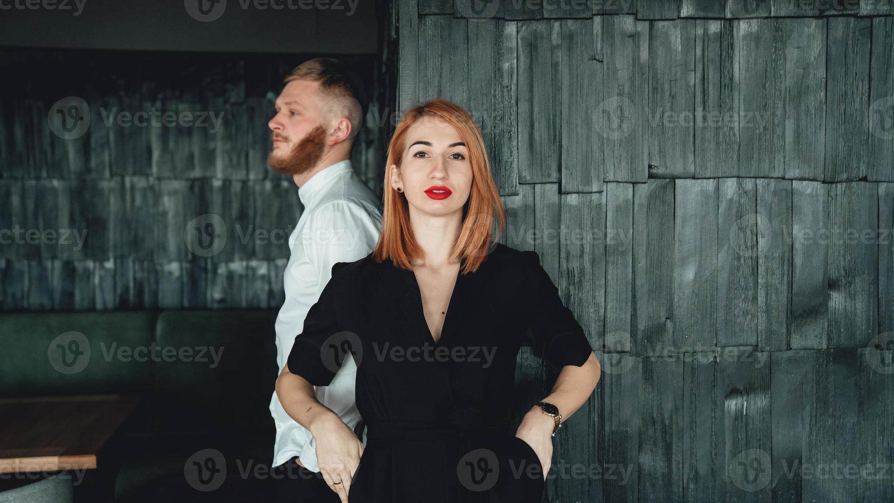 A young woman and her boyfriend are posing for the camera indoors. photo