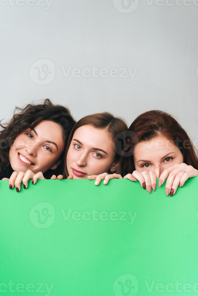 Three beautiful young girls posing for the camera photo