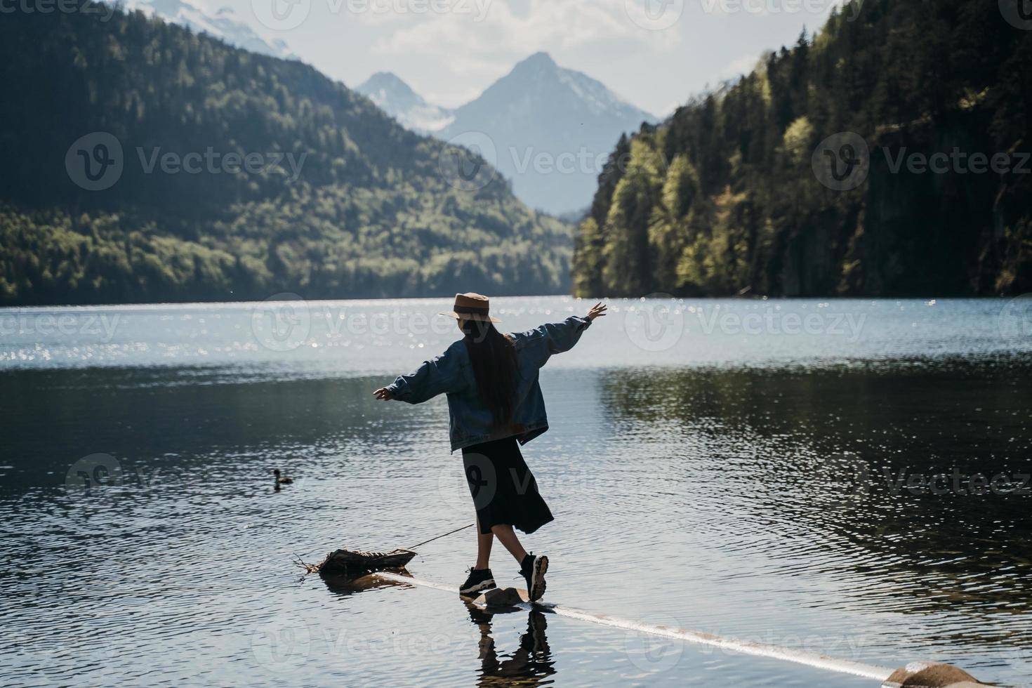 The girl in the dress and hat of the lake in the mountains photo