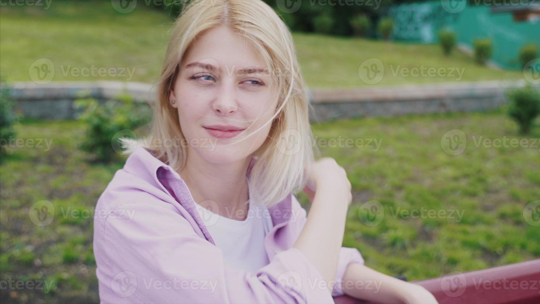 Portrait of attractive hipster girl resting on park wooden bench photo