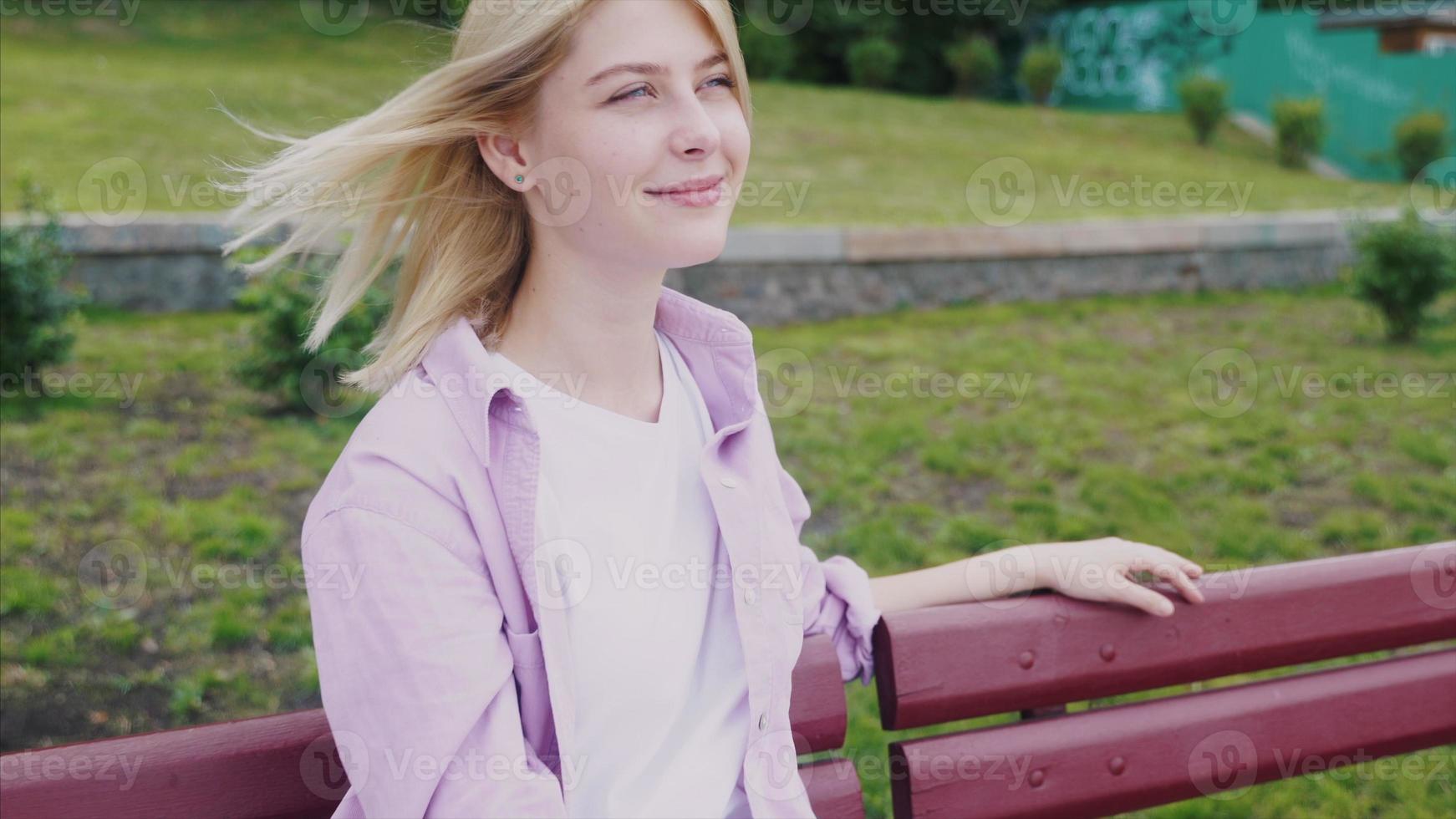 Portrait of attractive hipster girl resting on park wooden bench photo