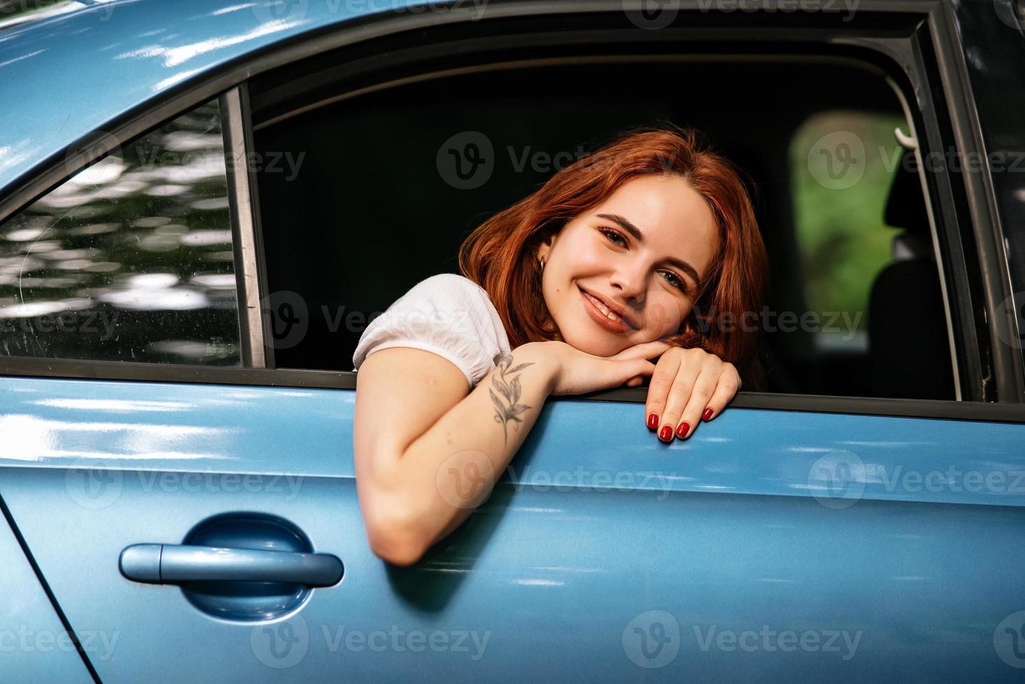 Portrait of of young woman looking at camera through window photo