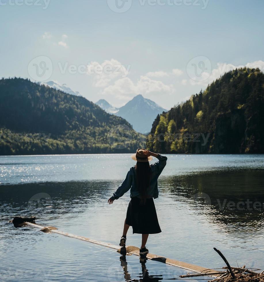 The girl in the dress and hat of the lake in the mountains photo
