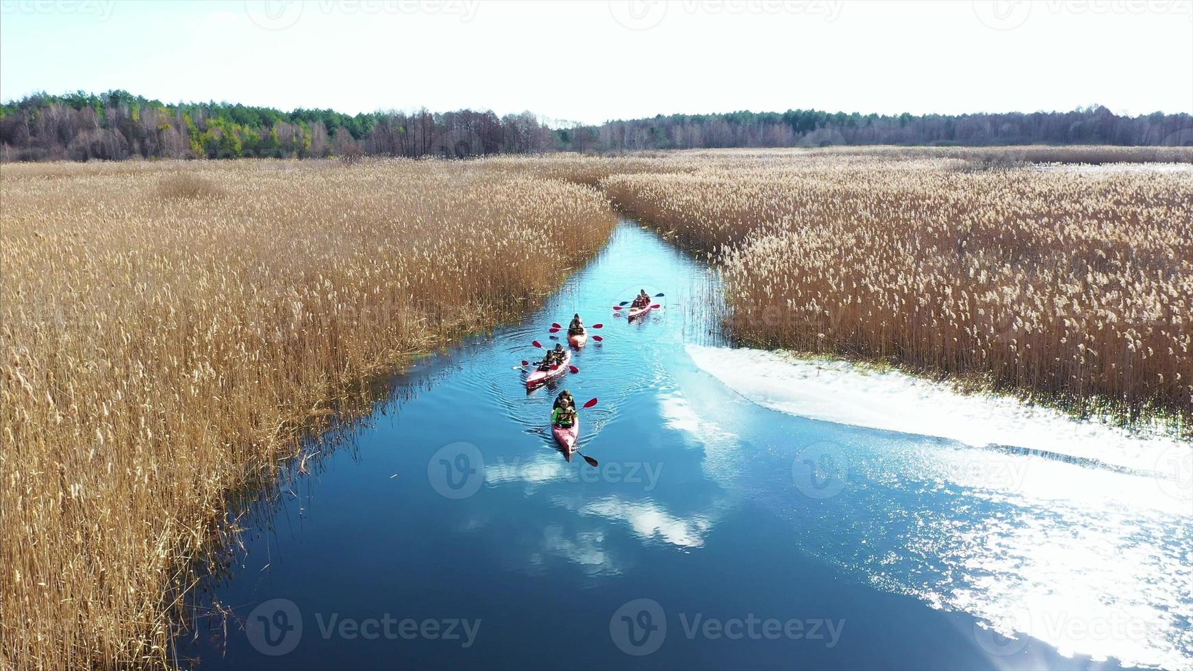 Group of people in kayaks among reeds on the autumn river. photo