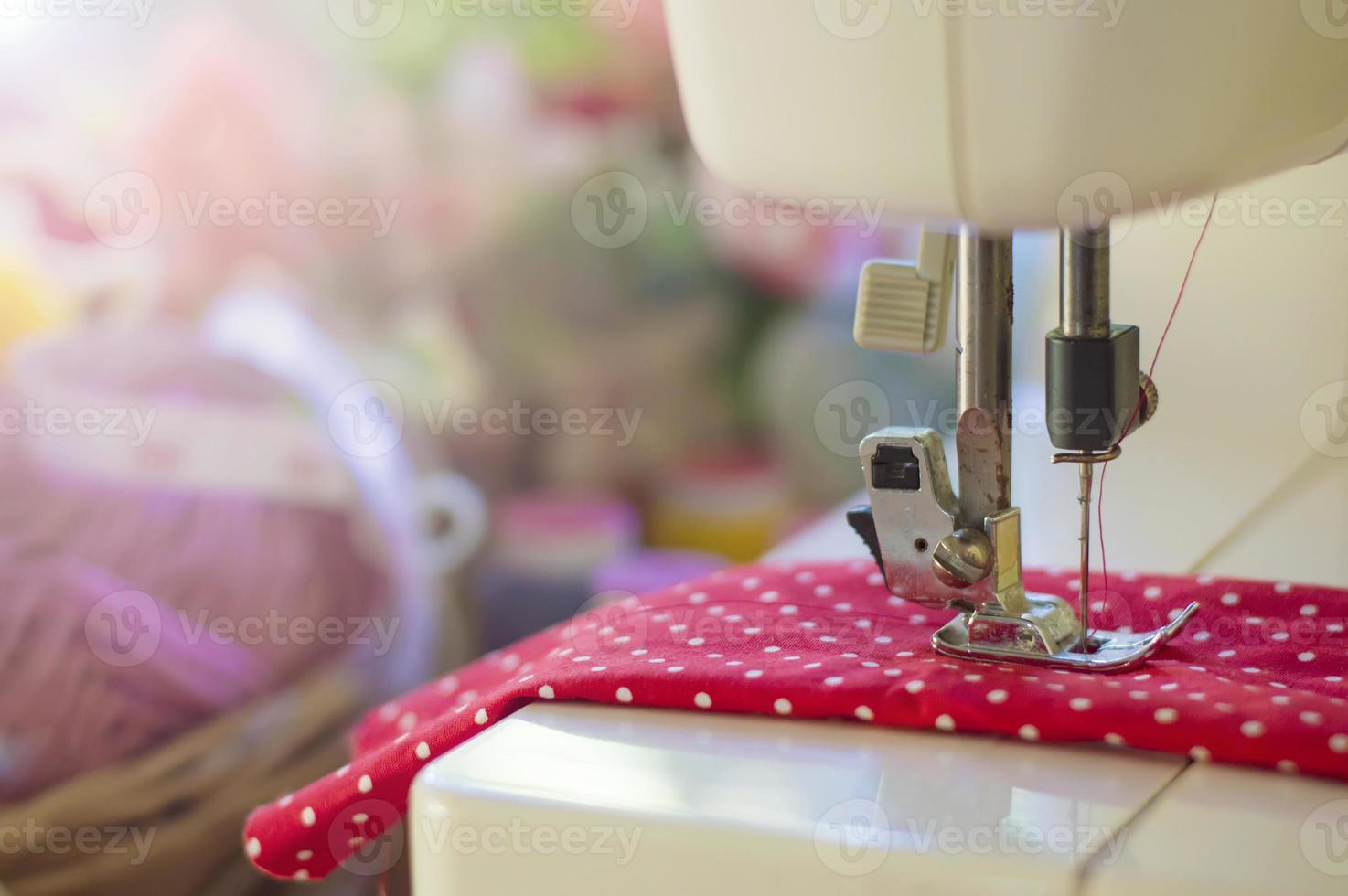 Close up of sewing machine working with red fabric photo