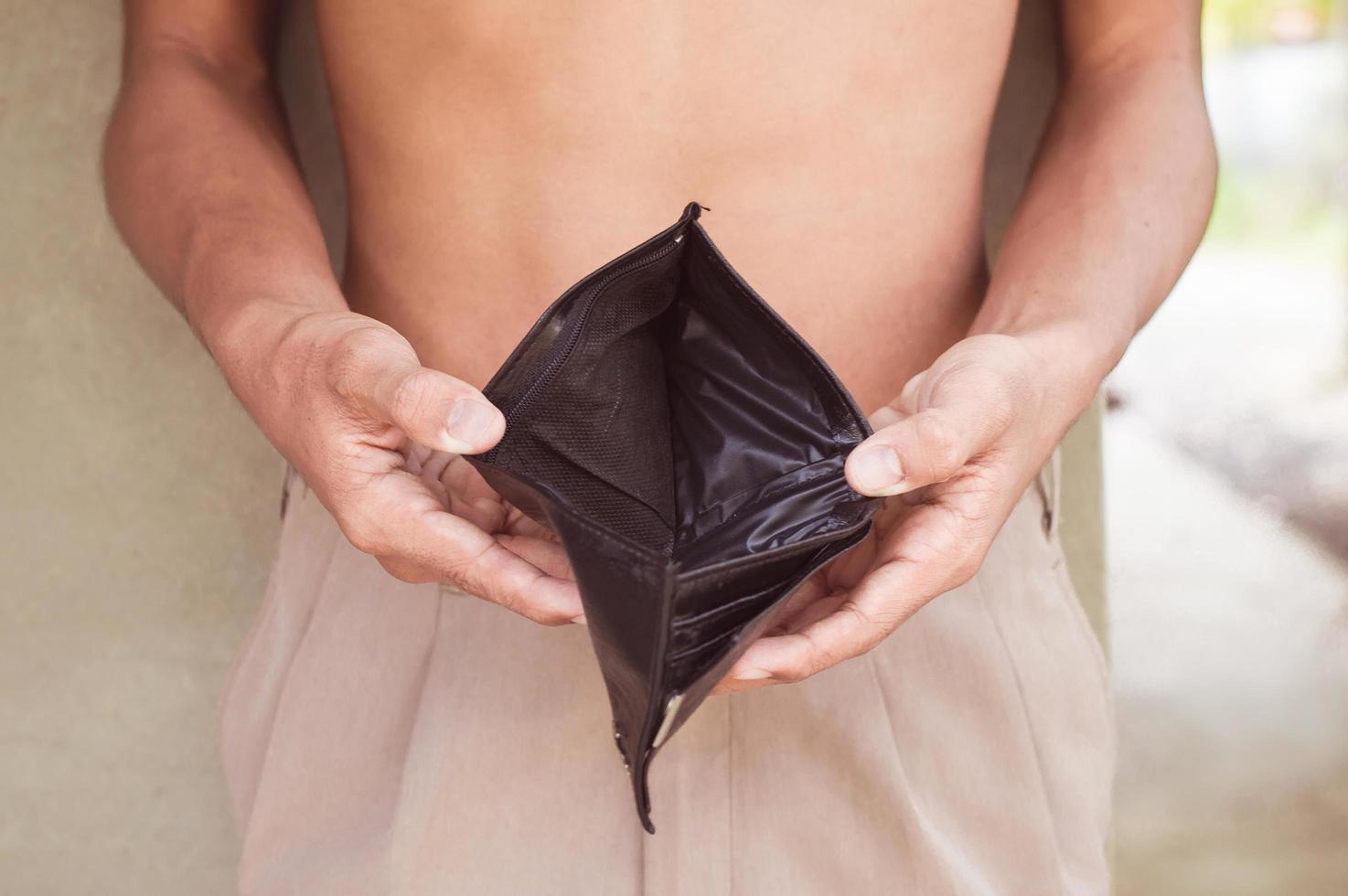 empty black wallet in man hand with vintage tone photo
