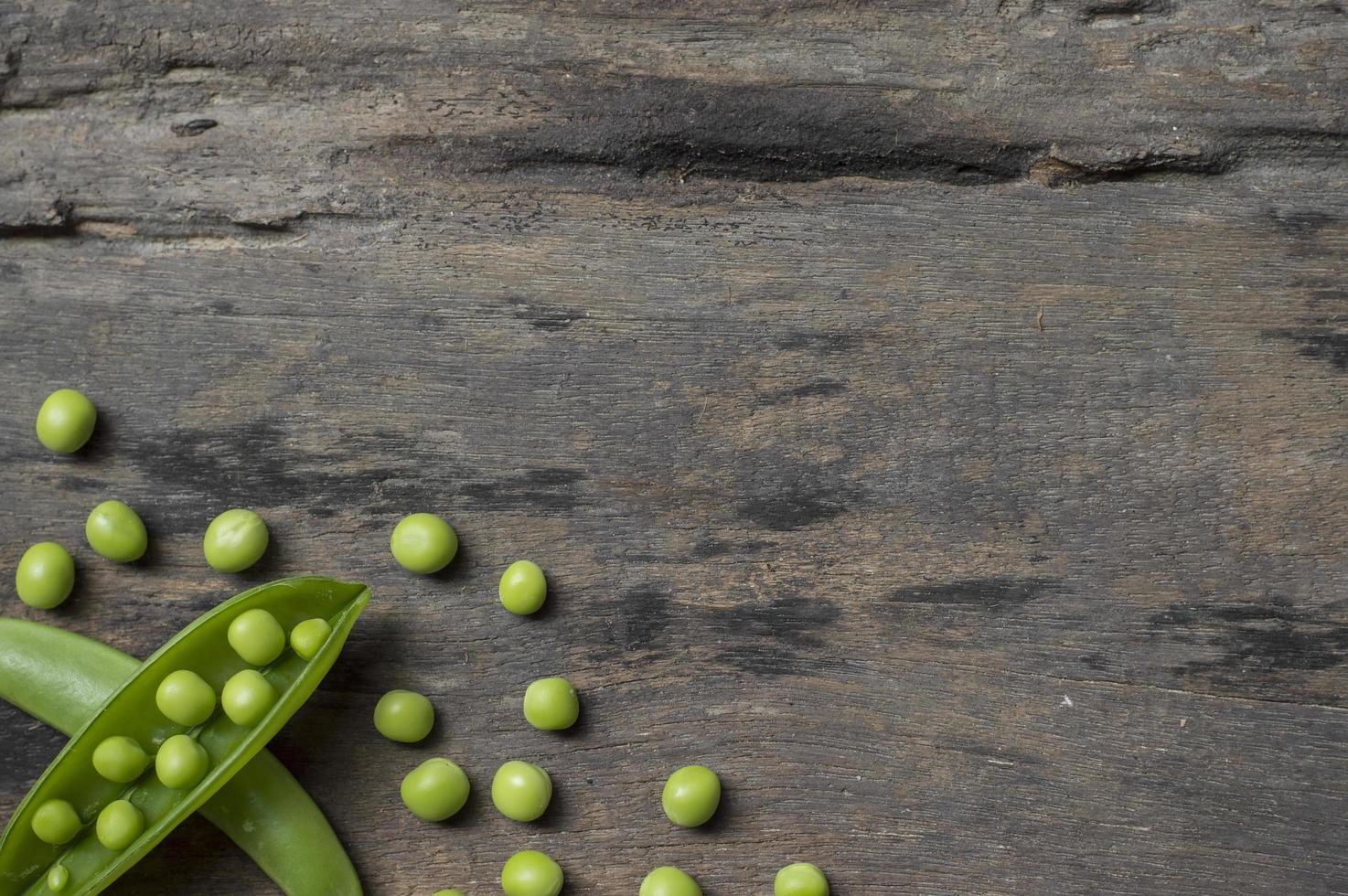 Green peas on old wooden table background photo