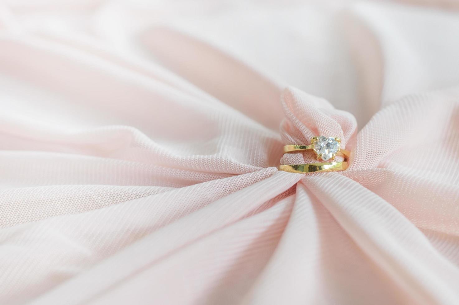 anillo de bodas en tela rosa para el día de san valentín o el fondo de la boda foto