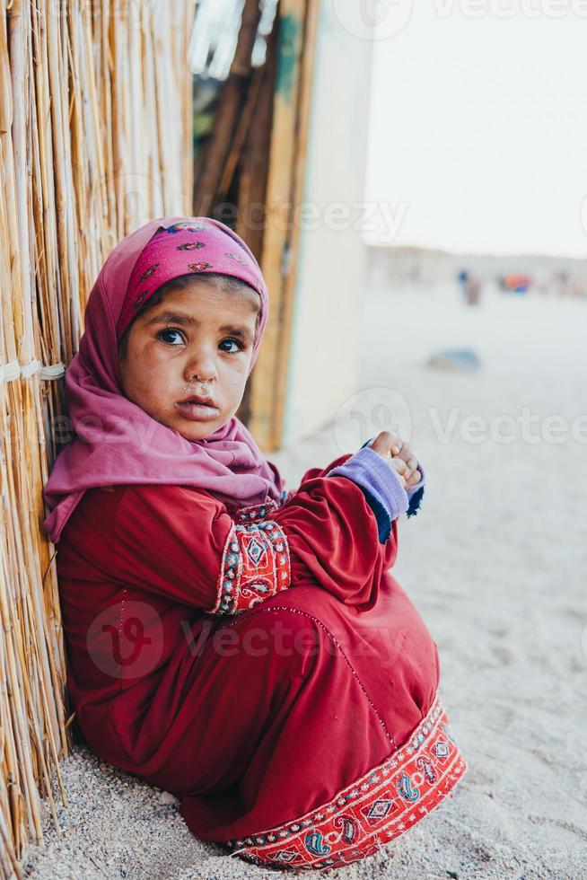 poor, sad little child girl sitting photo