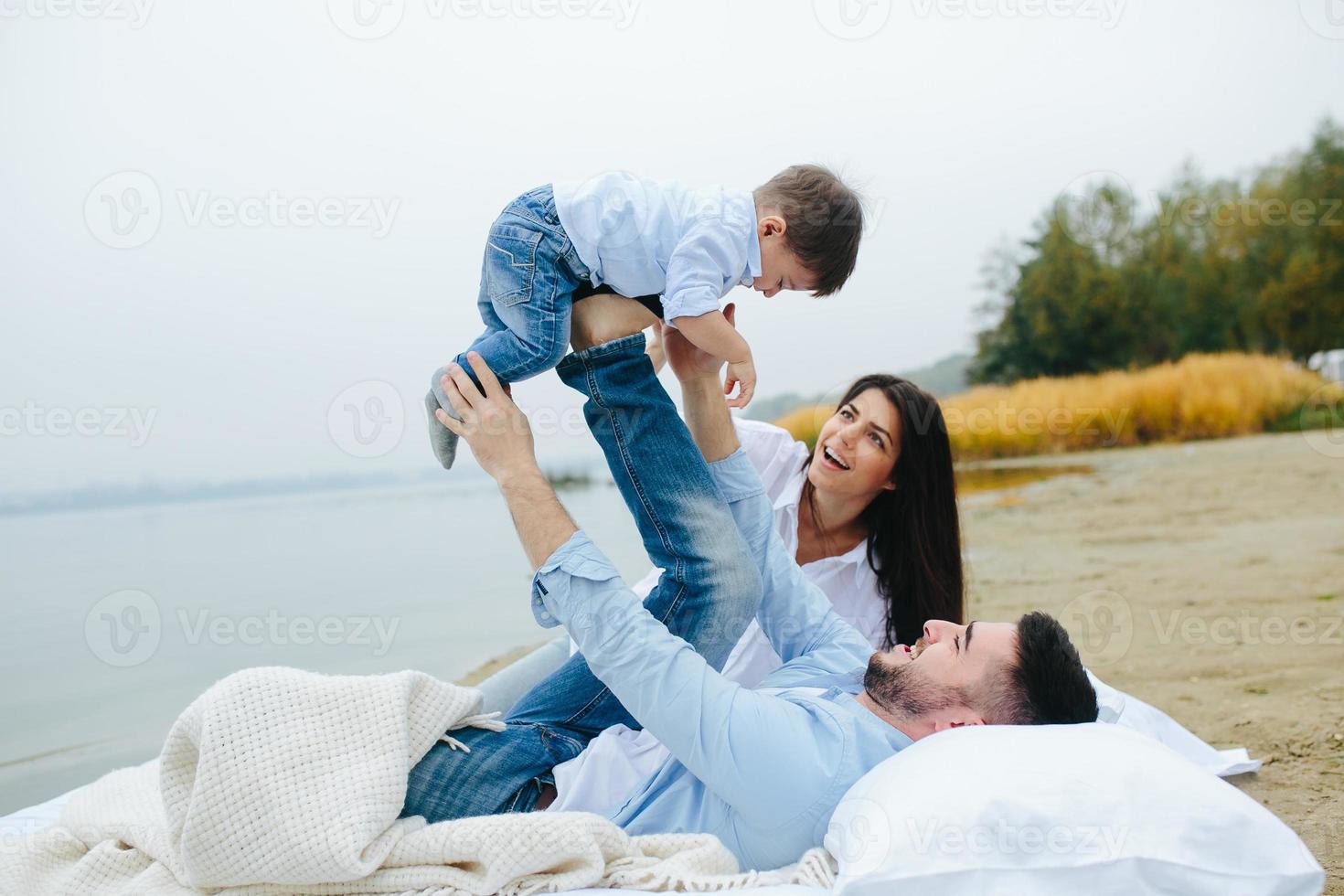 Happy young family relaxing together on the lake photo