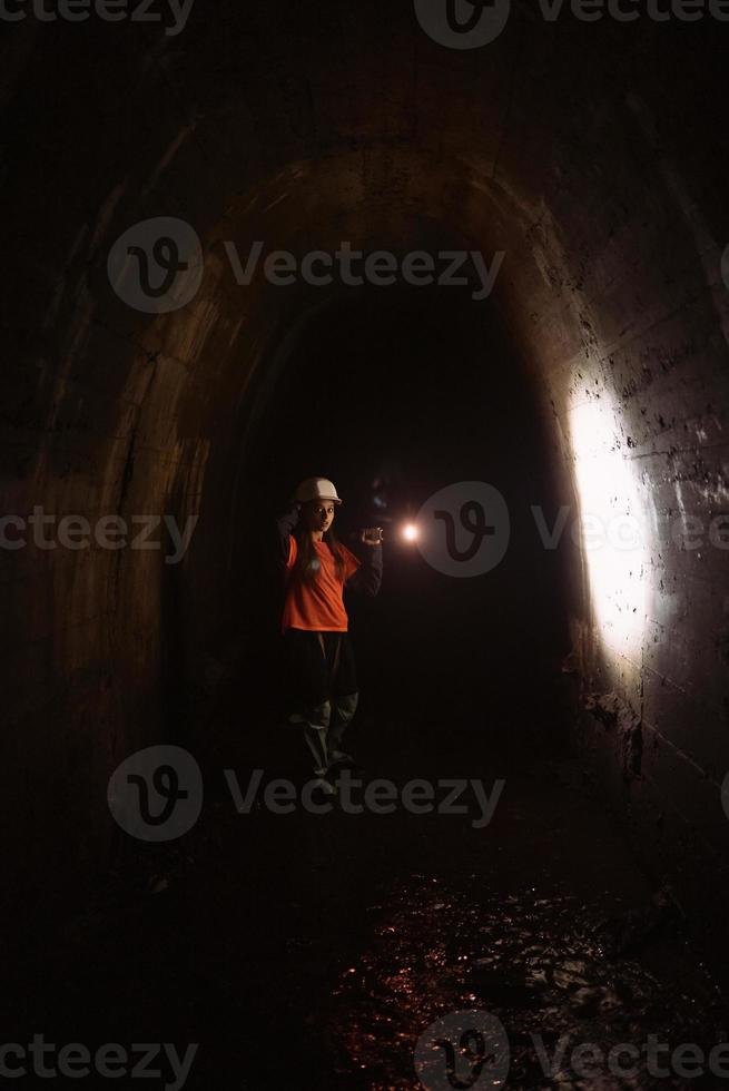 Female digger with flashlight explores the tunnel photo