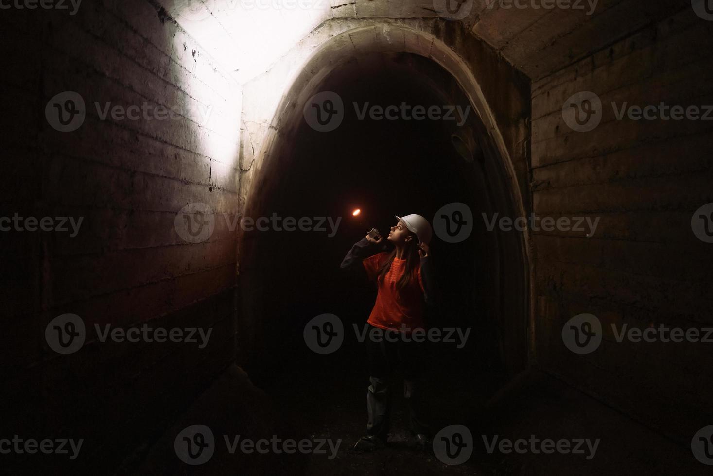 Female digger with flashlight explores the tunnel photo