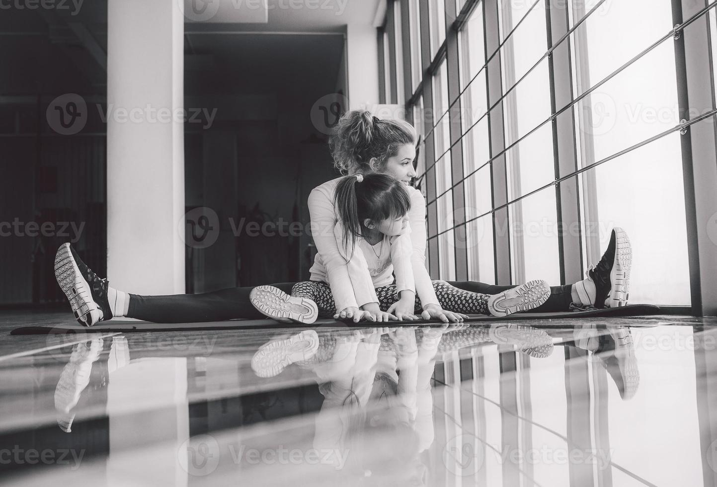 Mother and daughter makeing yoga in the gym photo