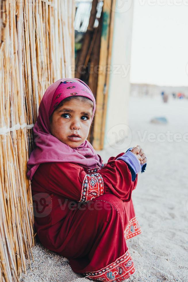 poor, sad little child girl sitting photo